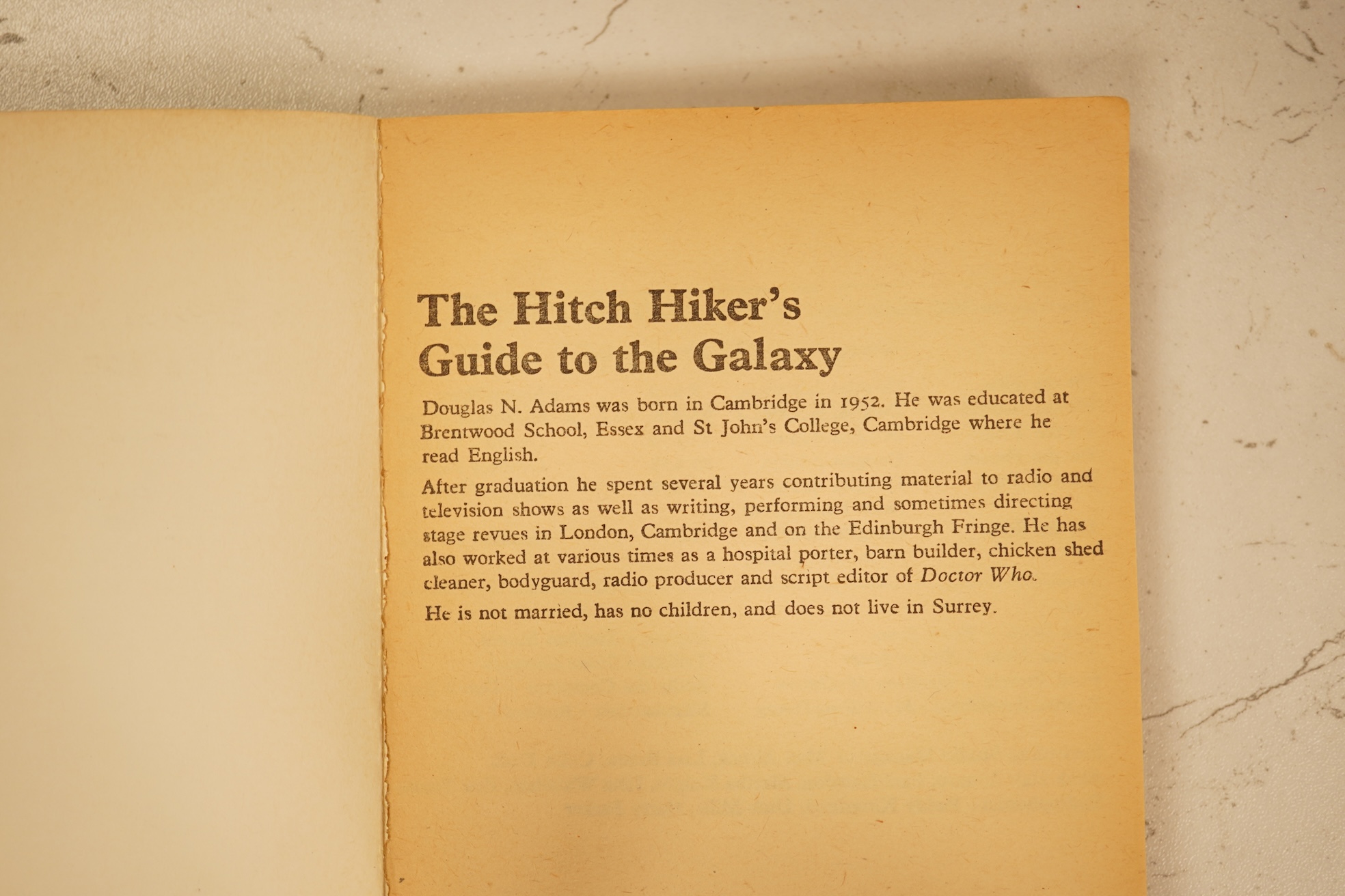 Adams, Douglas - The Hitch Hiker's Guide to the Galaxy. first edition, 2nd printing. half title/radio series leaf; paperback, sm. 8vo. Pan Books, 1979. *published same year as first and with a differently designed cover;